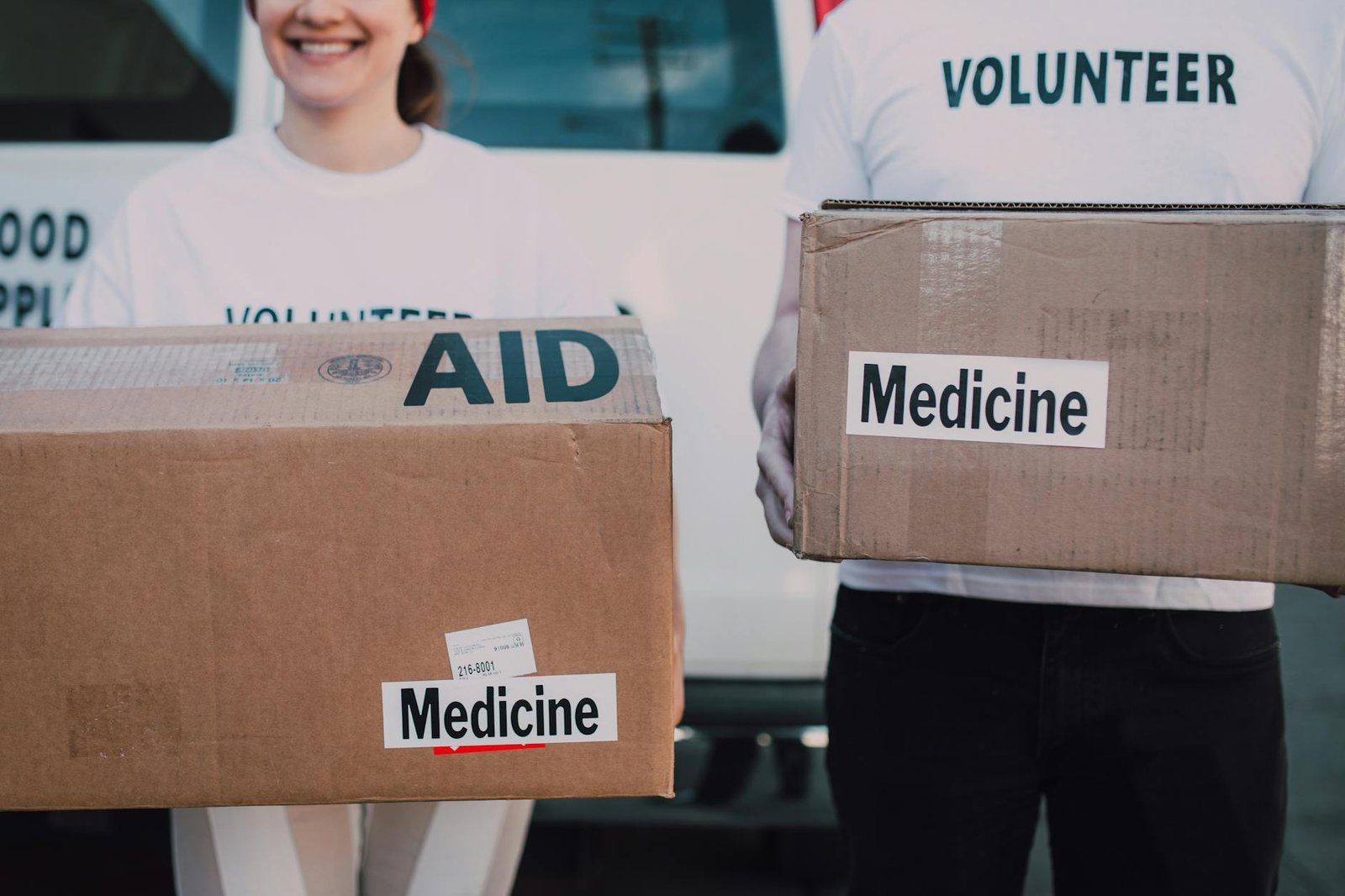 Volunteers preparing aid boxes labelled Aid and Medicine