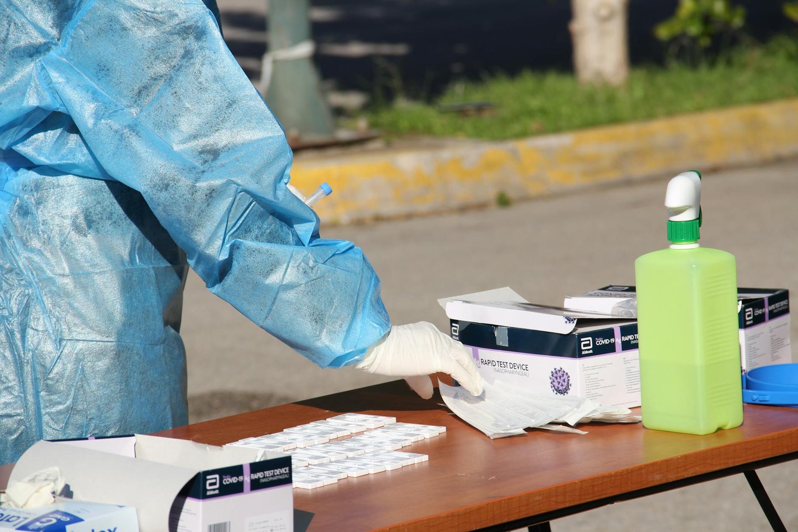 Healthcare worker in protective gear conducting COVID-19 testing